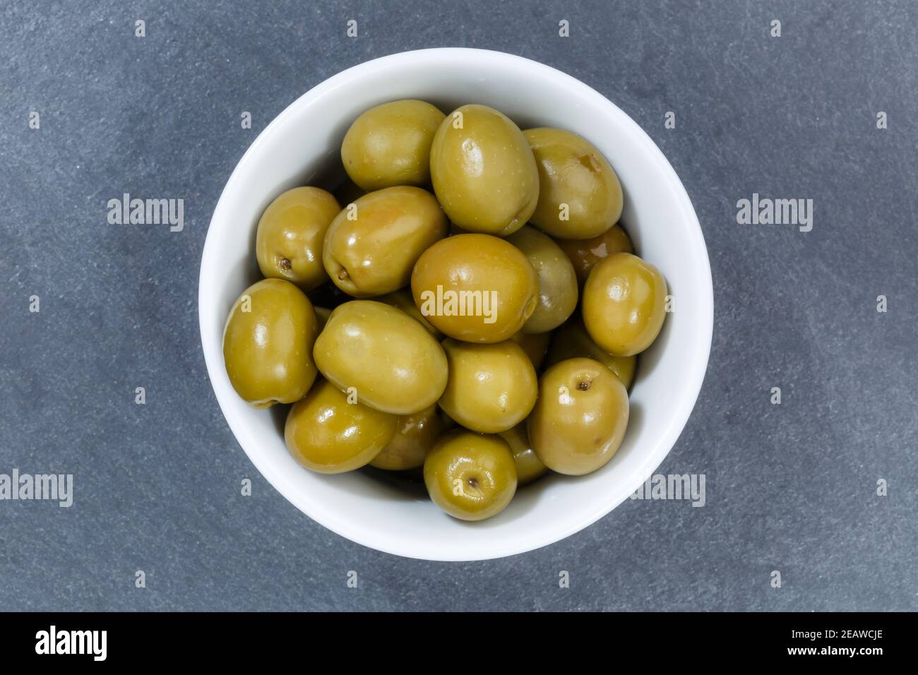 Olives vert olive du dessus bol sur une ardoise Banque D'Images