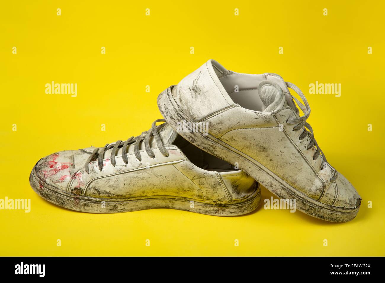 Chaussures sales, sneakers vintage blanc déchiré isolées sur fond jaune  Photo Stock - Alamy