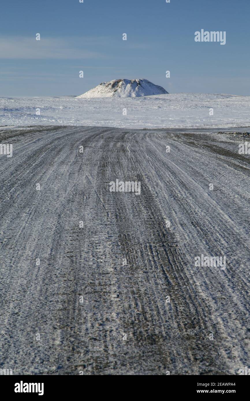 Un point de repère de pingos (colline à corées de glace intra-pergélisol) le long de la route en gravier Inuvik-Tuktoyaktuk en hiver, Territoires du Nord-Ouest, Arctique canadien. Banque D'Images