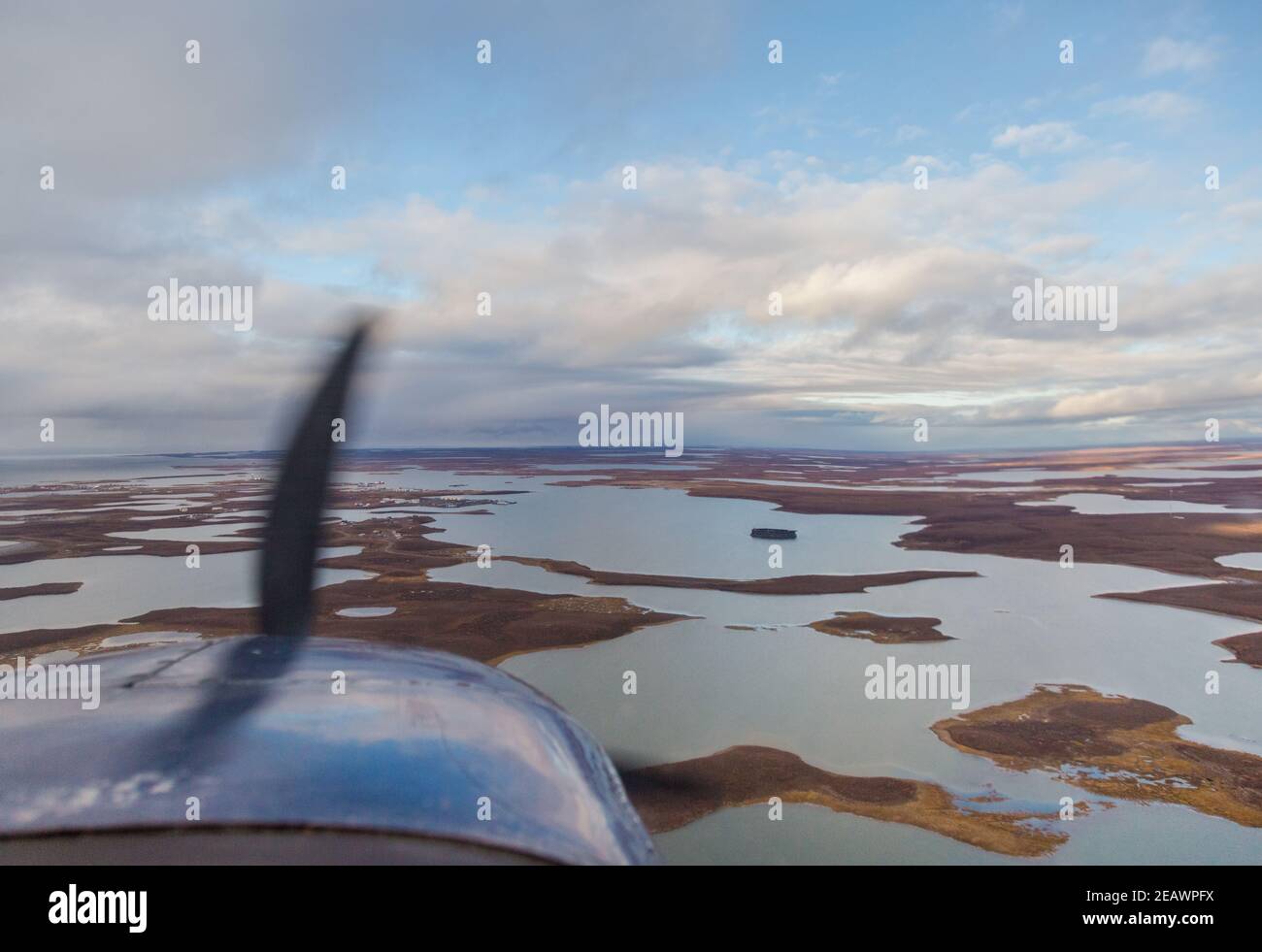 Vue depuis la fenêtre de l'avion du Cessna 207, volant dans l'Arctique canadien au-dessus des plans d'eau en direction de Tuktoyaktuk (Territoires du Nord-Ouest). Banque D'Images