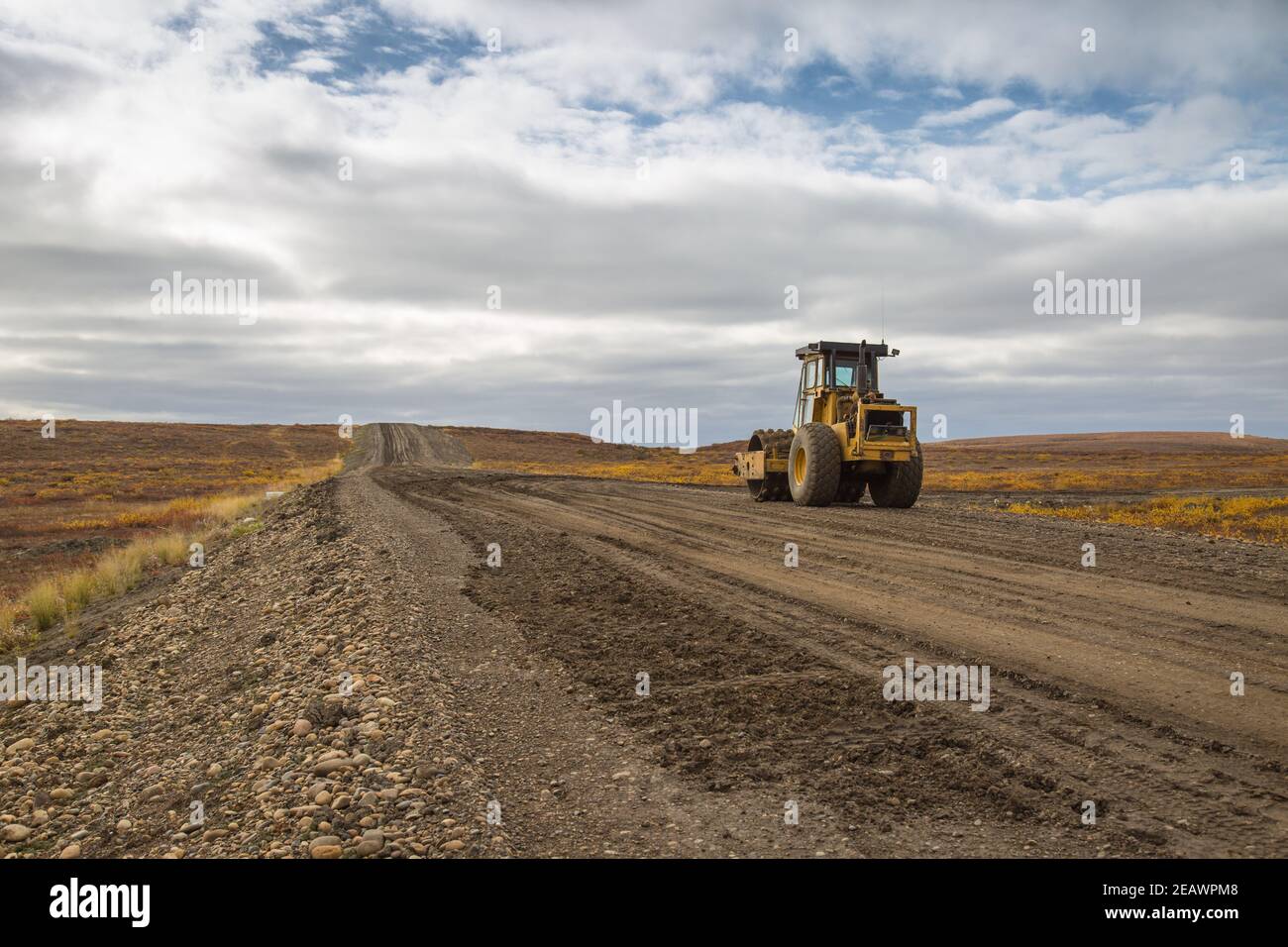 Compacteur de sol vibrant sur la route Inuvik-Tuktoyaktuk (construite au-dessus du pergélisol) pendant la construction automnale, Territoires du Nord-Ouest, Arctique canadien. Banque D'Images