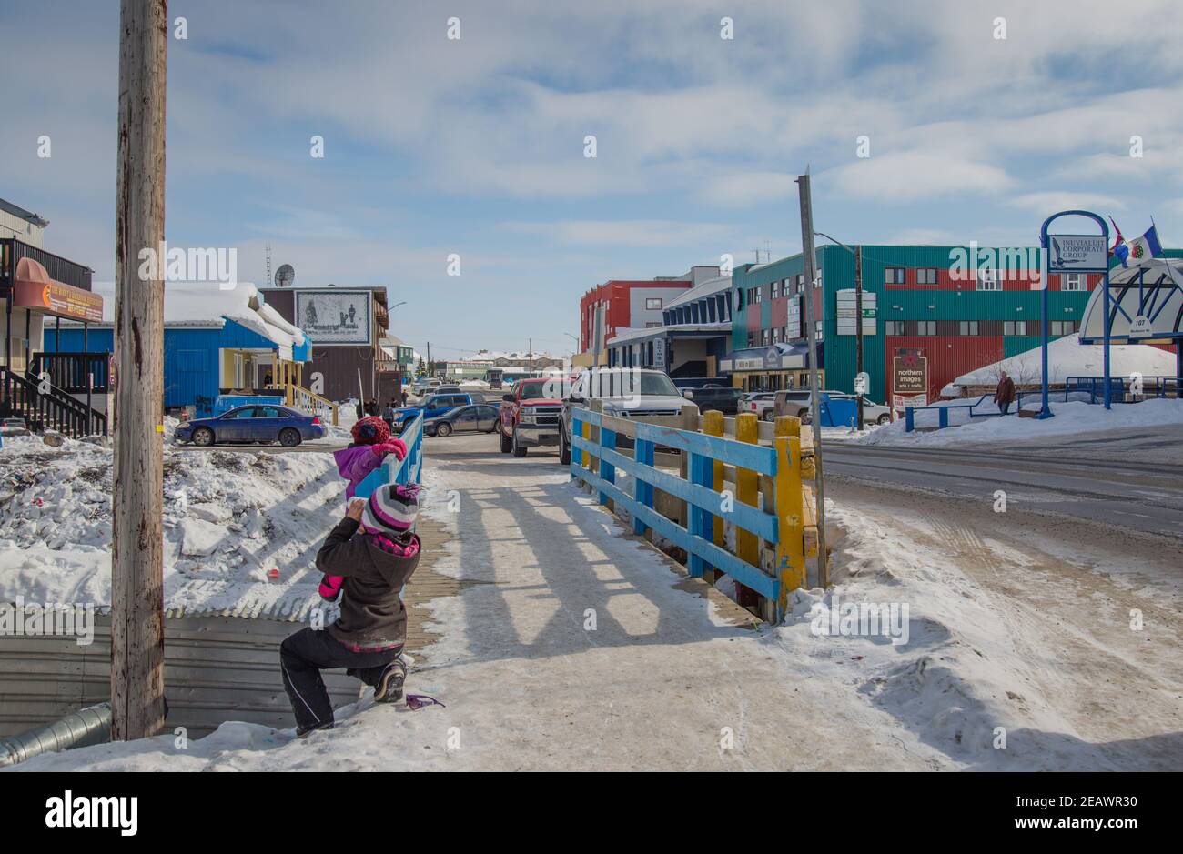 Enfants jouant le long de la rue principale au centre-ville d'Inuvik en hiver, dans les Territoires du Nord-Ouest, dans l'ouest de l'Arctique canadien. Banque D'Images
