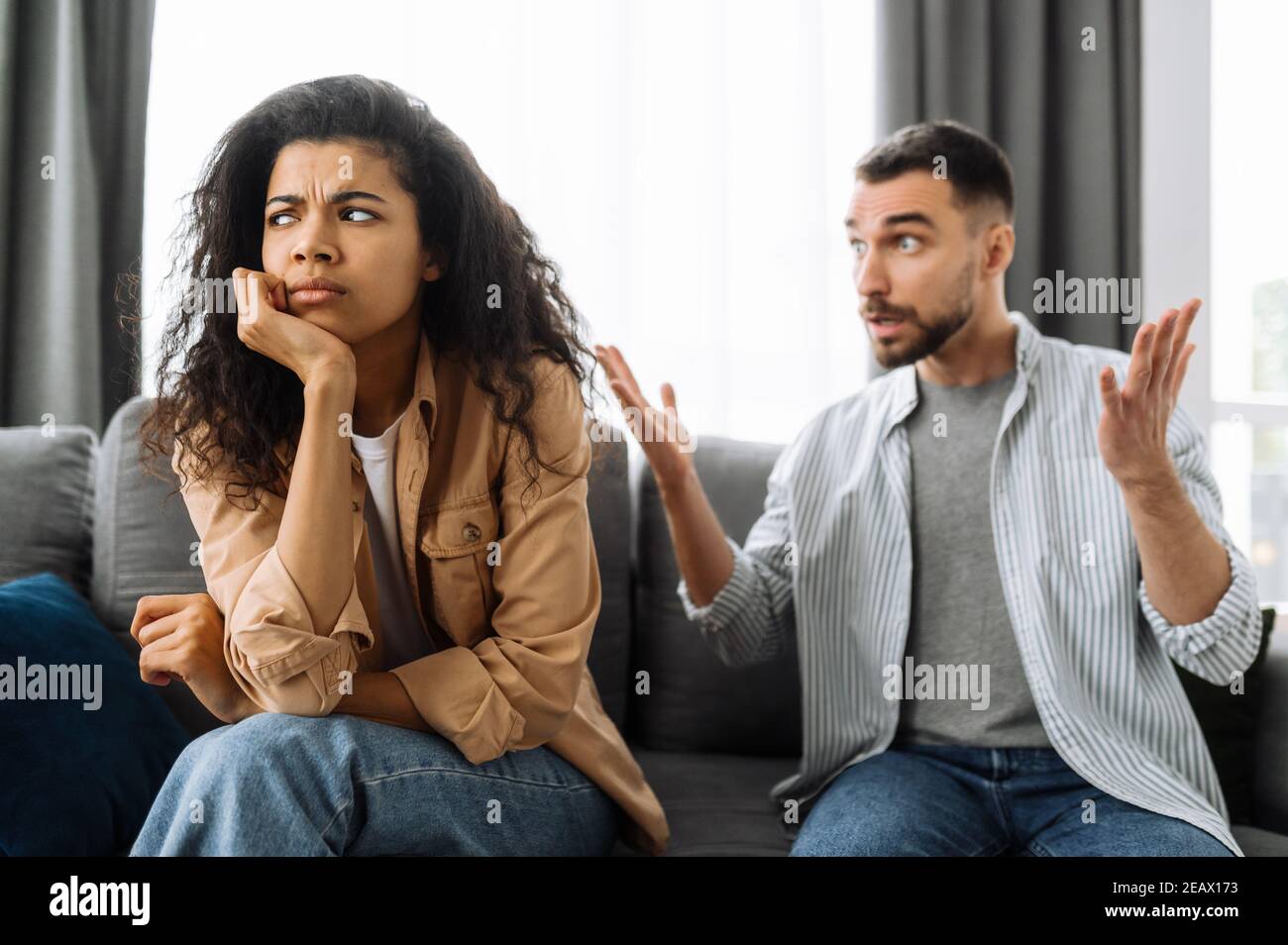 Couple jeune marié émotionnellement discuter de quelque chose, ils ont le problème. La femme afro-américaine et l'homme caucasien en désaccord les uns avec les autres ont un Banque D'Images