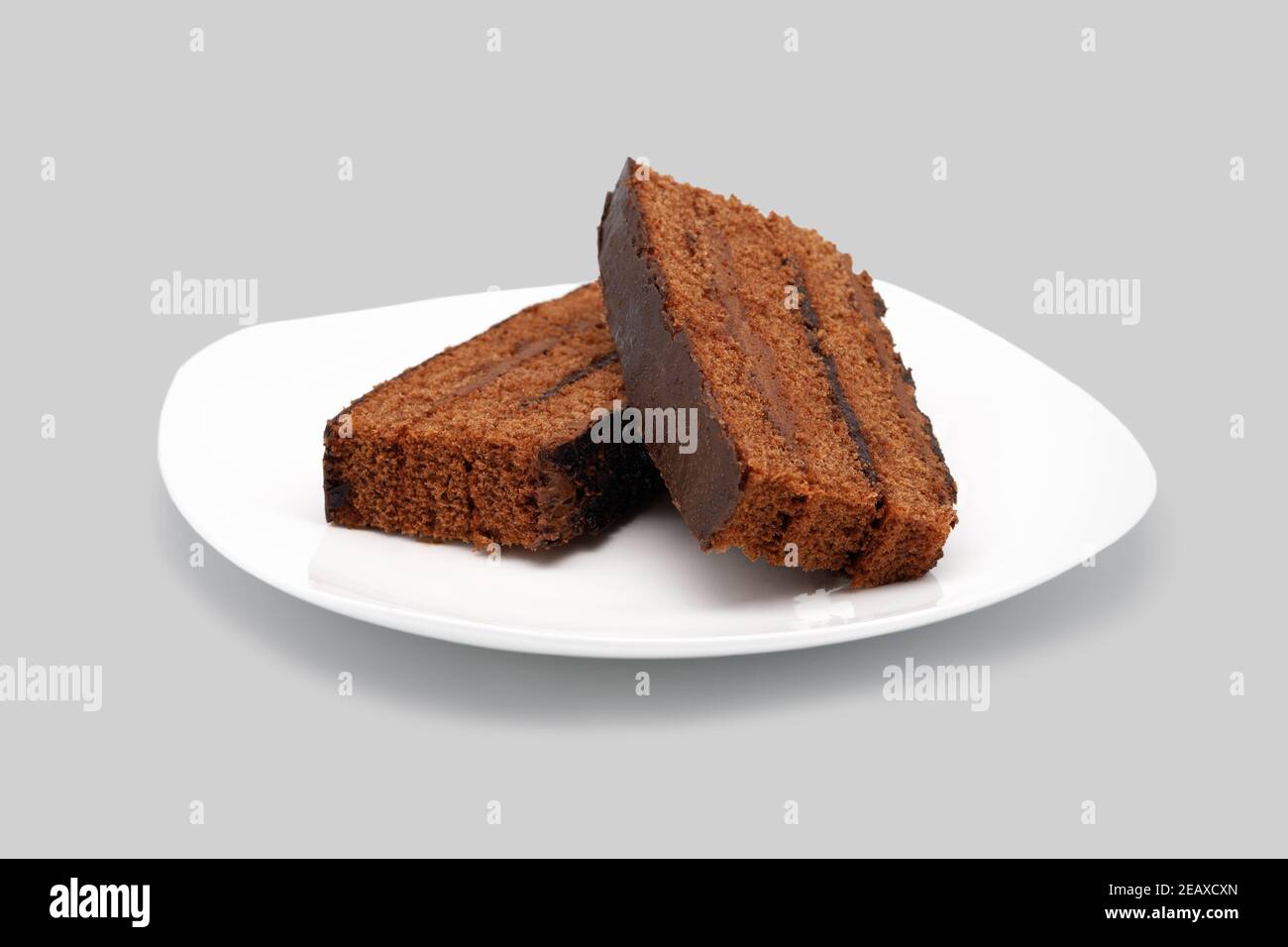 Morceaux de gâteau sur une assiette blanche. Gros plan. Isolé sur fond blanc. Banque D'Images
