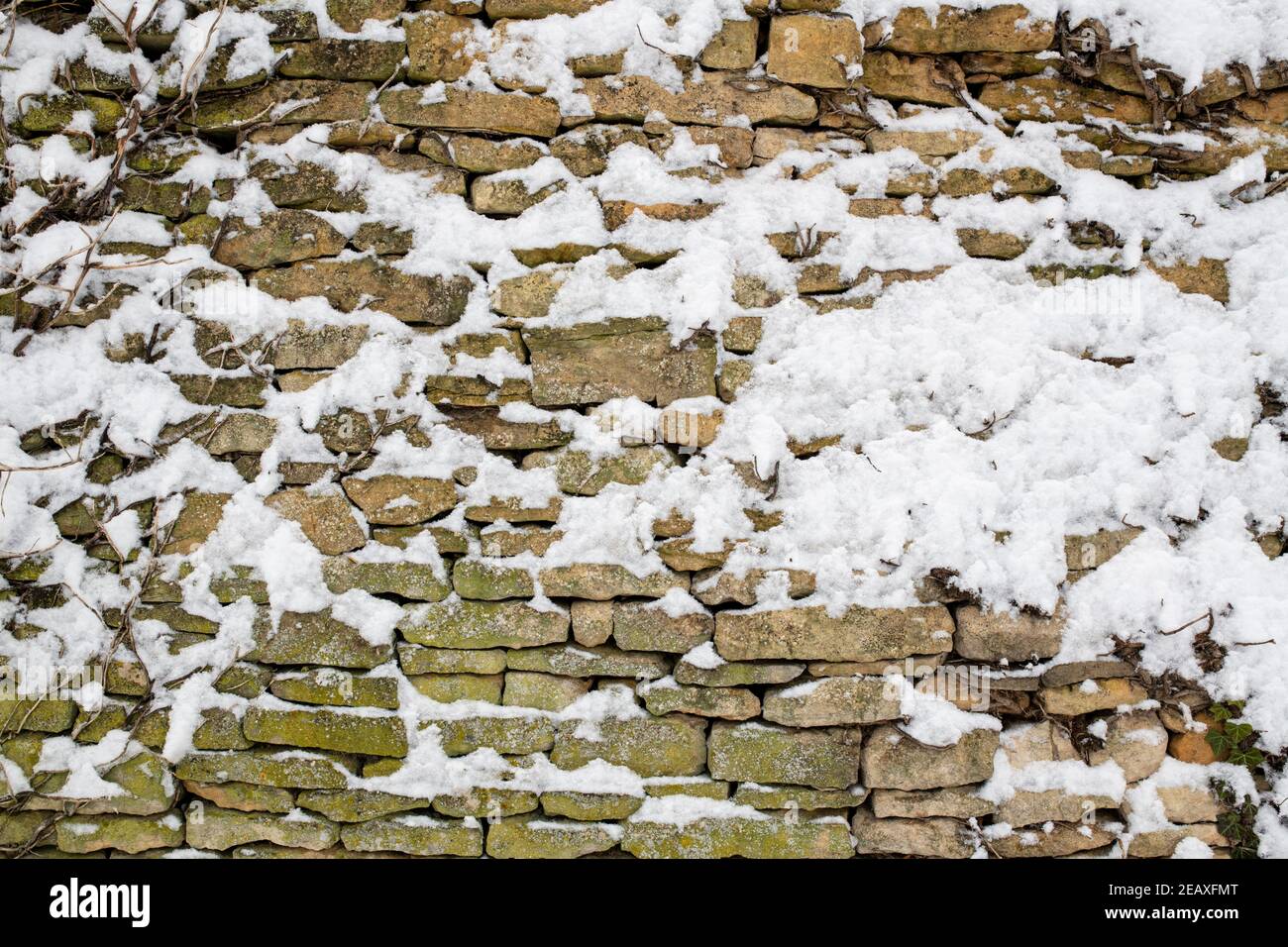 Jardin Cotswold mur en pierre recouvert de neige. Swinbrook, Cotswolds, Oxfordshire, Angleterre Banque D'Images