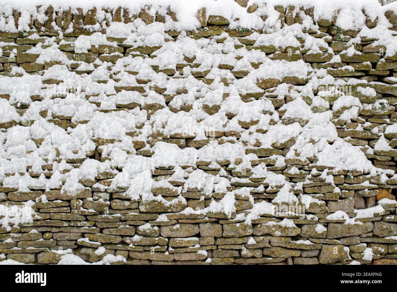 Jardin Cotswold mur en pierre recouvert de neige. Swinbrook, Cotswolds, Oxfordshire, Angleterre Banque D'Images