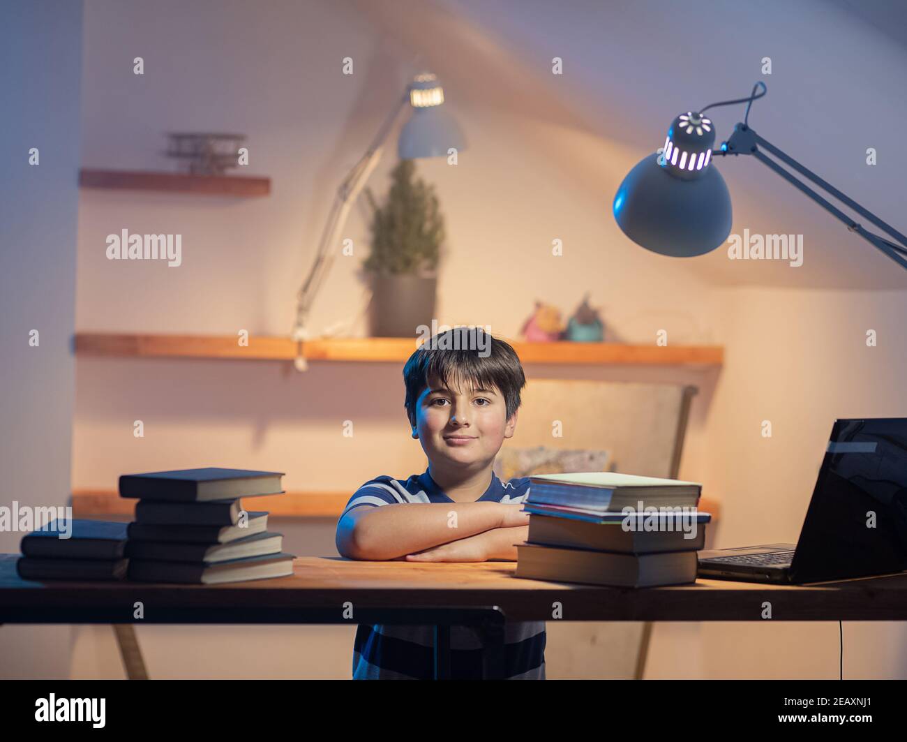 Portrait d'un garçon dans sa chambre à une table de travail. Émotion de satisfaction et zèle sur le visage de l'enfant Banque D'Images