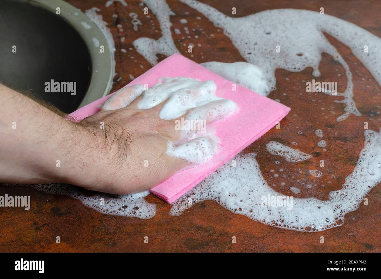 Lave-mains homme cuisine Table Rose viscose plat Rag. Nettoyage, lave-vaisselle, tâches ménagères. Gros plan, mise au point sélective. Banque D'Images