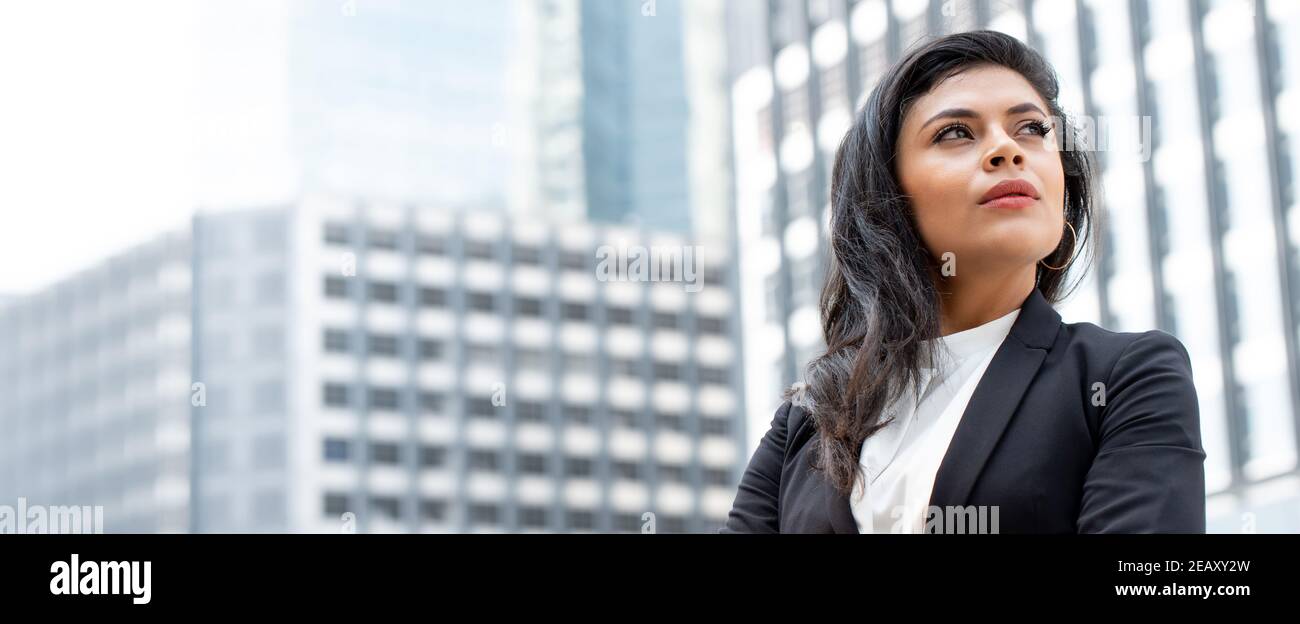 Puissante femme d'affaires latine debout dans la bannière de bâtiment de bureau de ville arrière-plan Banque D'Images