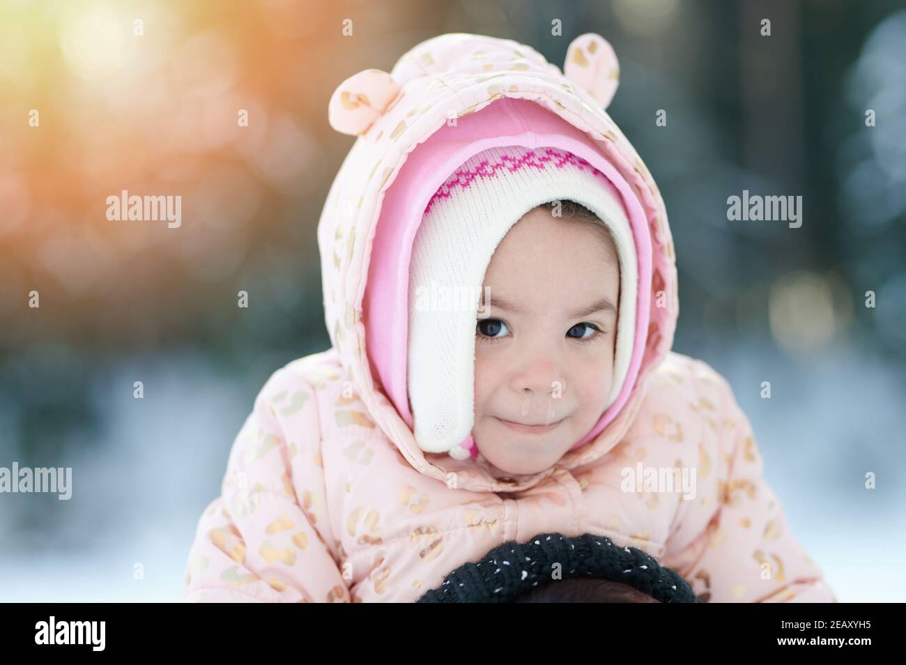 Portrait d'hiver d'un enfant avec nez de course sur un parc ensoleillé arrière-plan Banque D'Images