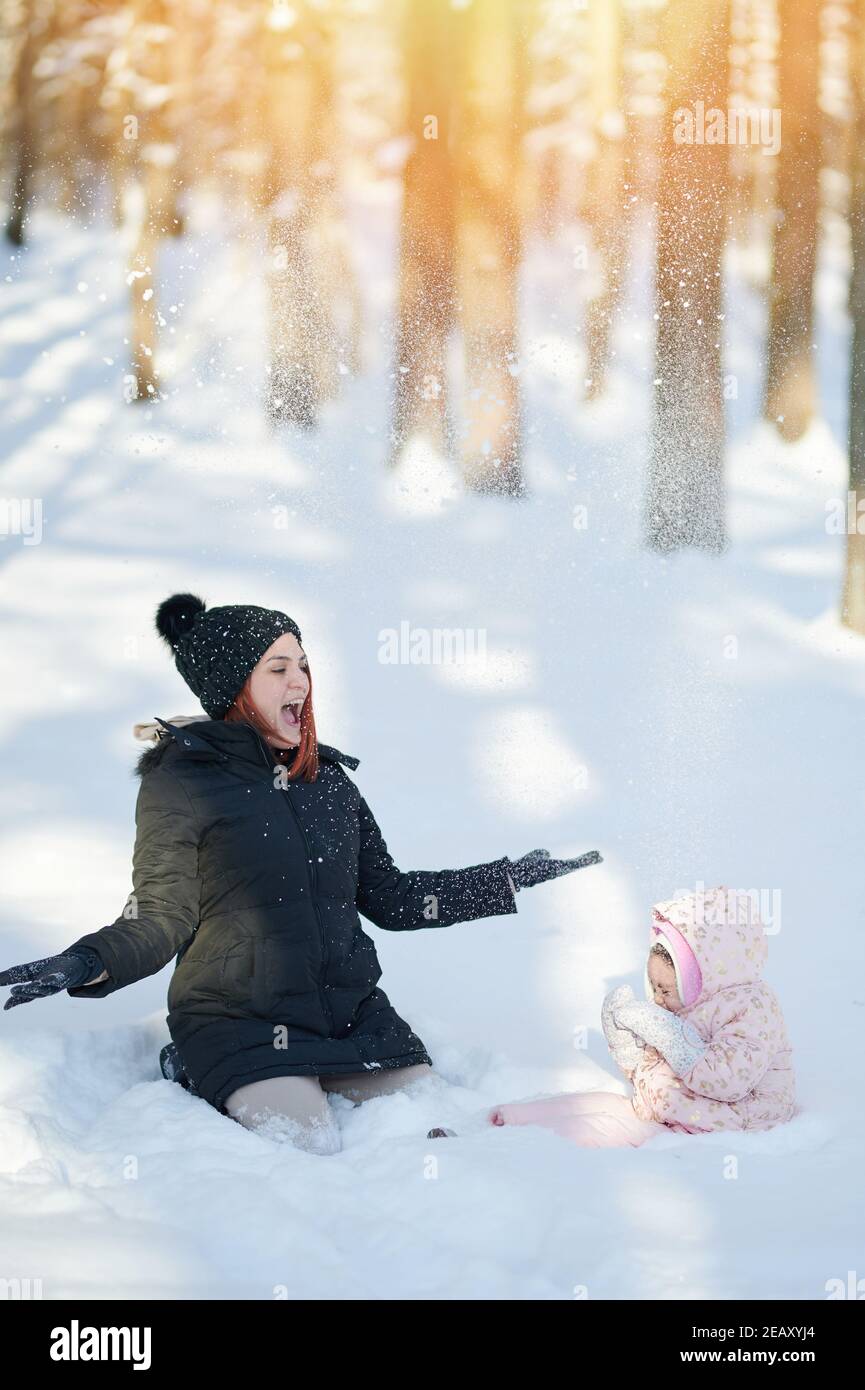 Je vous souhaite un plaisir de jouer en famille avec la neige le jour d'hiver ensoleillé Banque D'Images