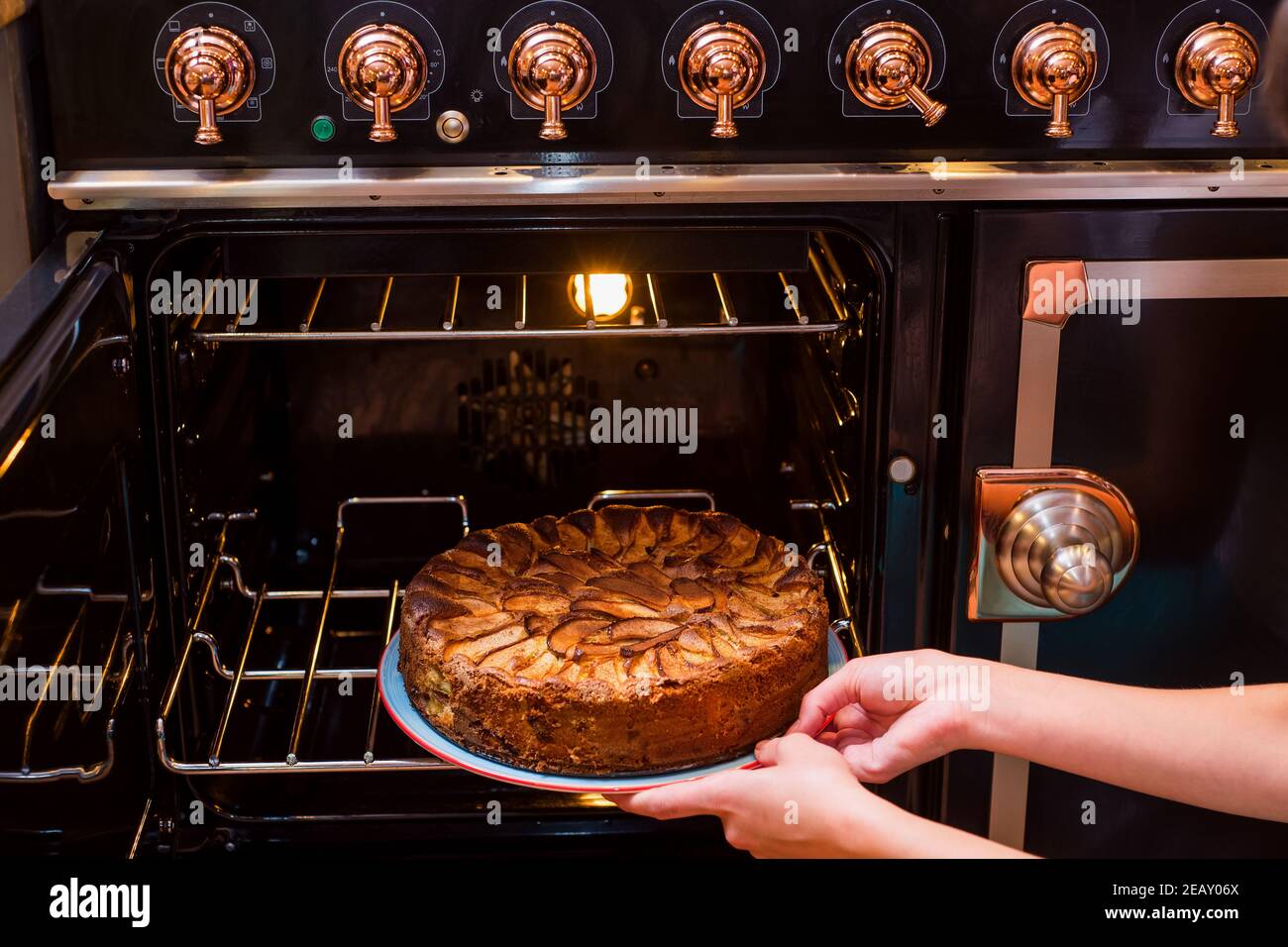 Les mains prennent la tarte aux pommes maison hors du four. Tarte aux pommes au four. Tarte traditionnelle aux pommes au four. Banque D'Images