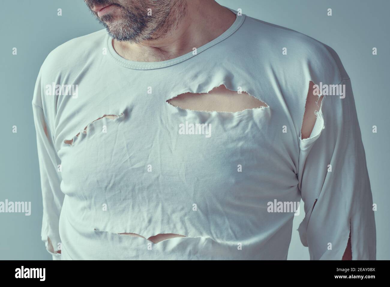 Victime masculine de violence et d'abus domestiques, image conceptuelle de l'homme adulte avec chemise déchirée, foyer sélectif Banque D'Images
