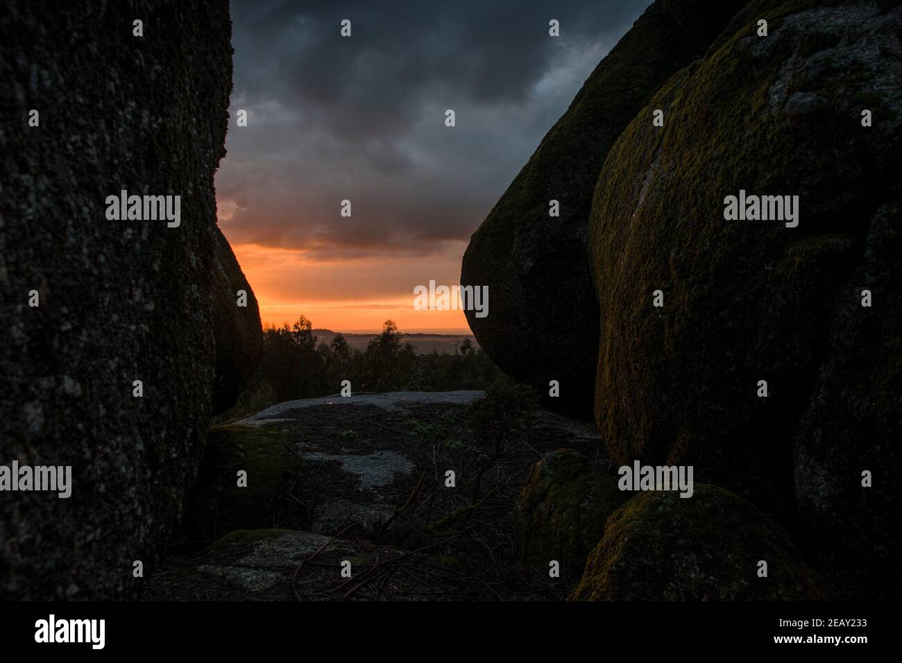 Placer avec beaucoup de grosses pierres couvertes de mousse dans un environnement orageux et jour de gris au coucher du soleil Banque D'Images