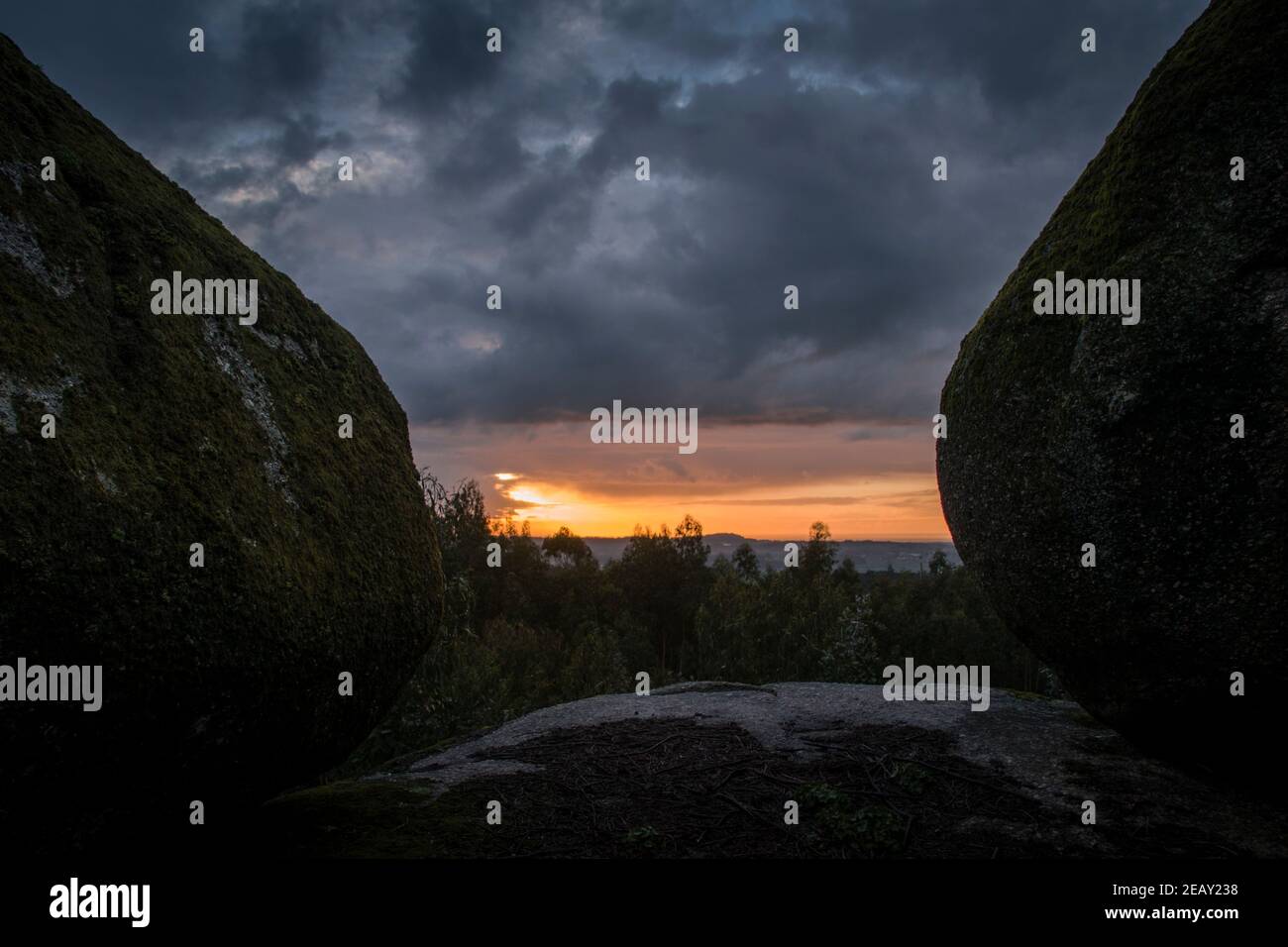 Placer avec beaucoup de grosses pierres couvertes de mousse dans un environnement orageux et jour de gris au coucher du soleil Banque D'Images