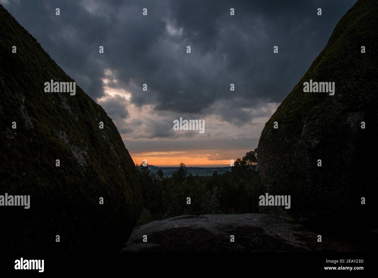 Placer avec beaucoup de grosses pierres couvertes de mousse dans un environnement orageux et jour de gris au coucher du soleil Banque D'Images