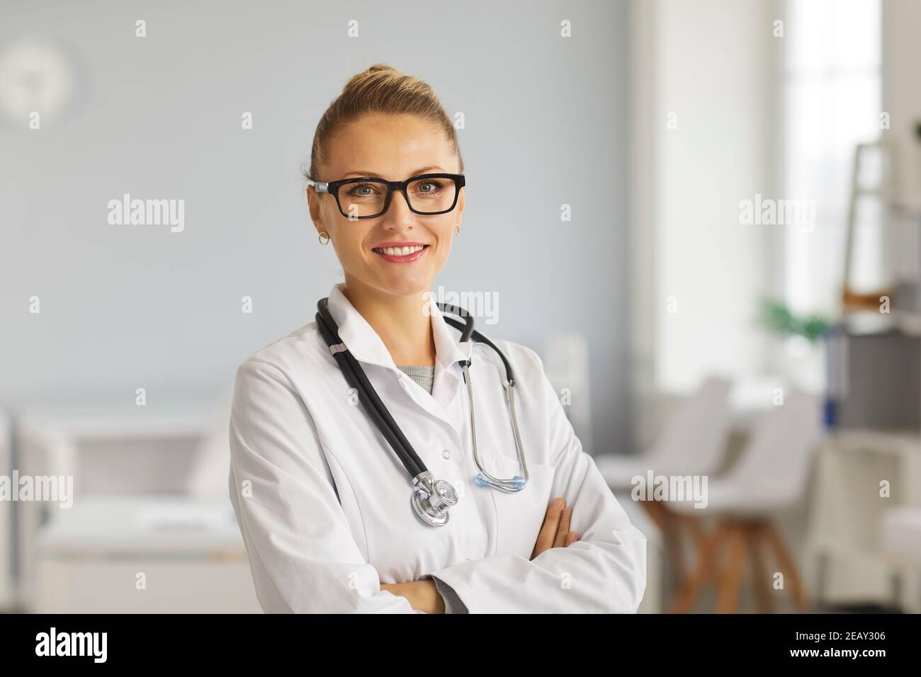 Portrait du jeune médecin heureux en blouse de laboratoire blanche et lunettes souriant à l'appareil photo Banque D'Images