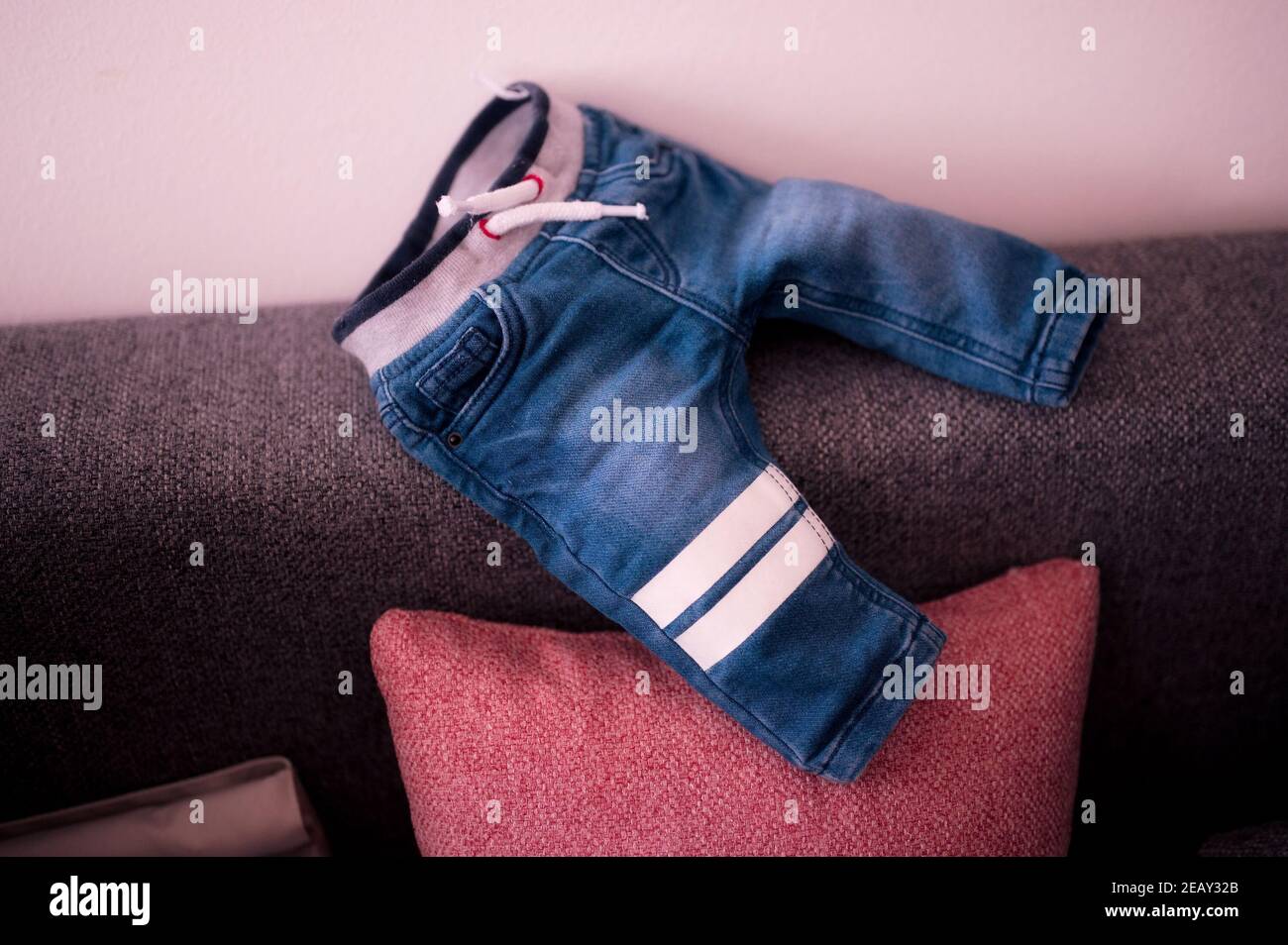 Pantalon jeans pour bébé sur le canapé Banque D'Images