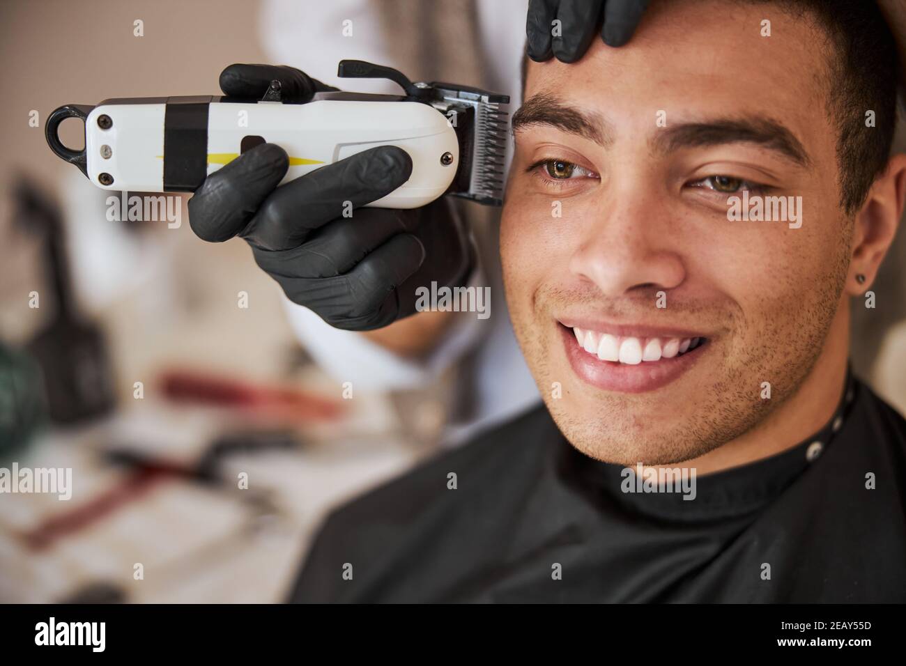 Un adorable homme indien se coiffant au salon de coiffure Banque D'Images