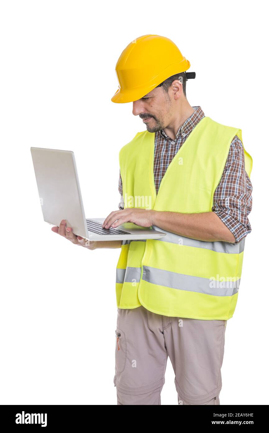 Homme de construction en casque et gilet réfléchissant debout sur blanc arrière-plan et navigation sur netbook Banque D'Images