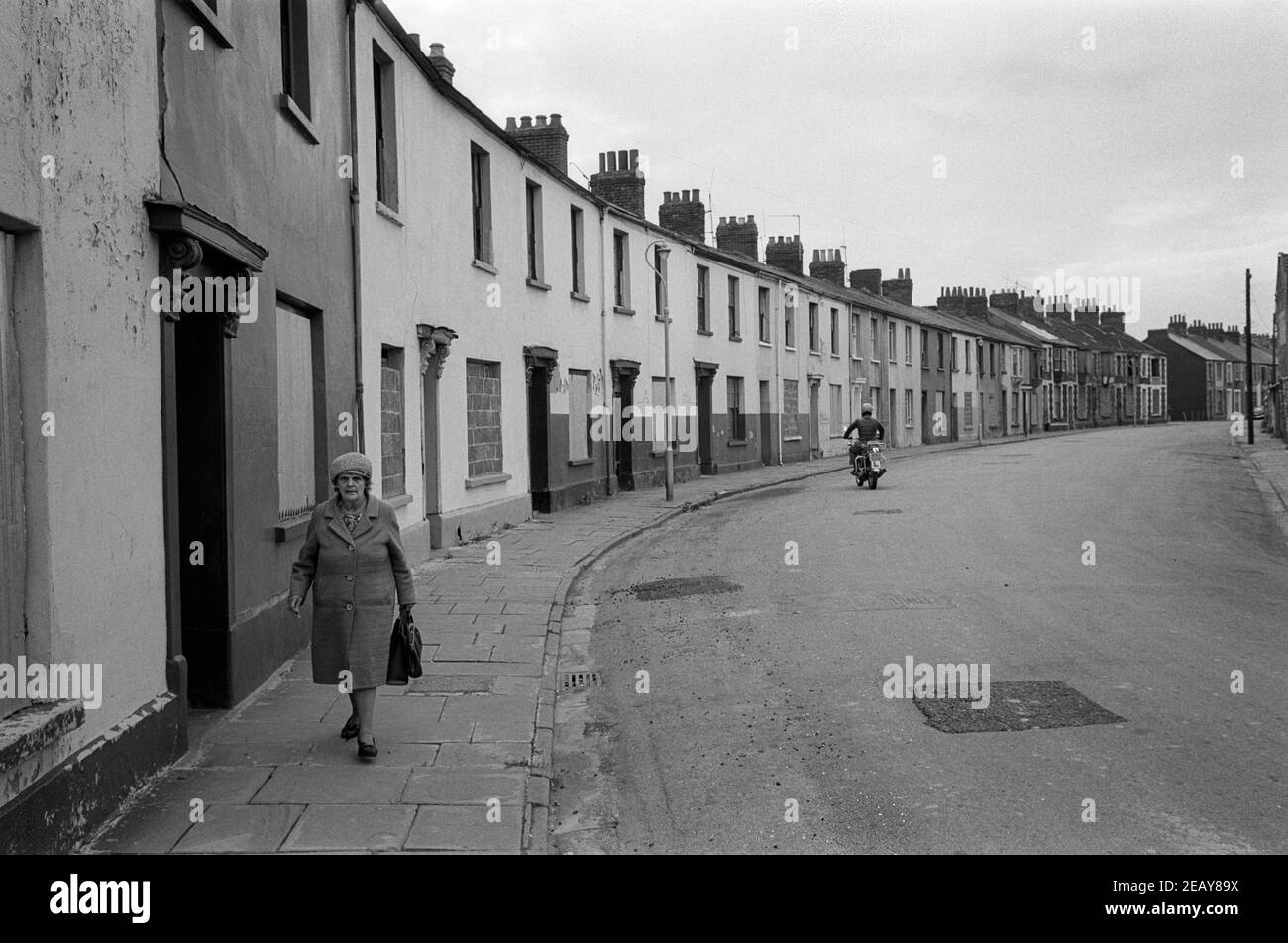 Une femme se rend dans les magasins locaux dans une rue pleine de maisons vivace en attendant la démolition, Capel Crescent, Pill, Newport, pays de Galles du Sud, 1976 Banque D'Images