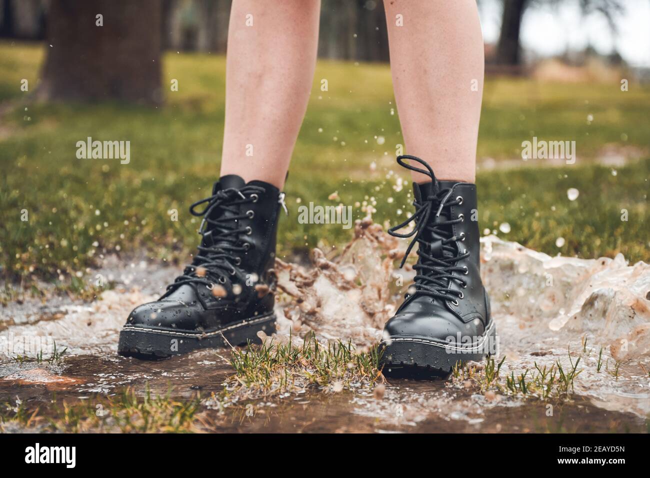 Photo sélective d'une femme portant des bottines noires sauter sur une  flaque dans un parc Photo Stock - Alamy