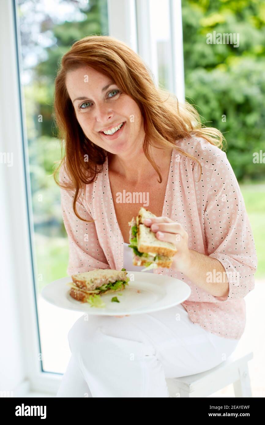 Femme en train de manger un sandwich Banque D'Images