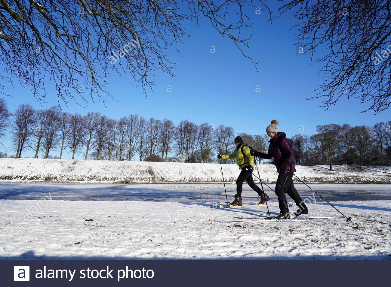 Édimbourg, Écosse, Royaume-Uni. 11 février 2021. Les gens apprécient un matin ensoleillé mais glacial dans un parc couvert de neige Inverleith. Le ski est un mode de transport privilégié. Crédit : Craig Brown/Alay Live News Banque D'Images