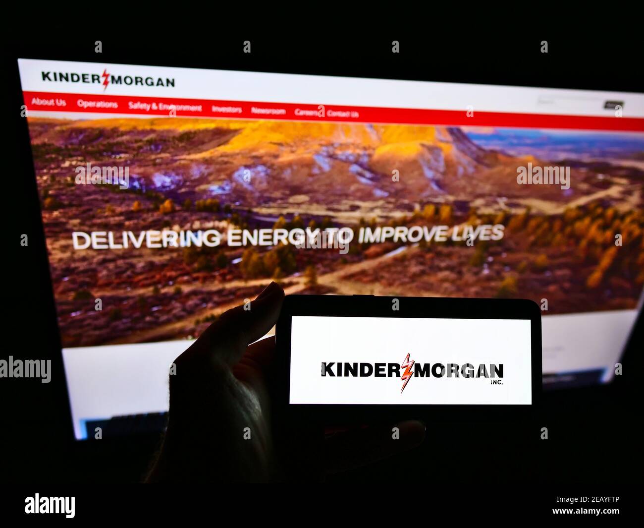 Personne tenant un smartphone avec le logo de la société américaine d'infrastructure énergétique Kinder Morgan Inc. À l'écran devant le site Web. Mise au point sur l'affichage du téléphone. Banque D'Images