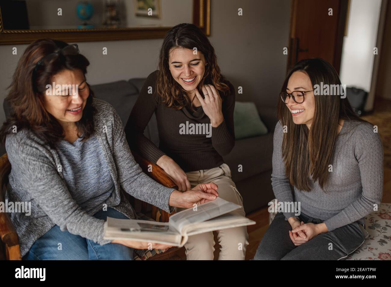 Trois femmes, mère et fille à la recherche d'un livre de souvenirs. Ensemble, concept de famille. Banque D'Images