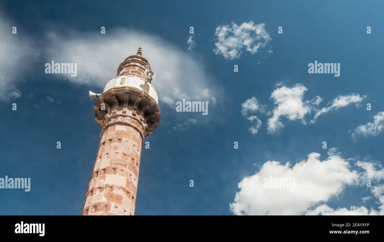 Vue sur le minaret d'une mosquée avec des nuages en mouvement Banque D'Images
