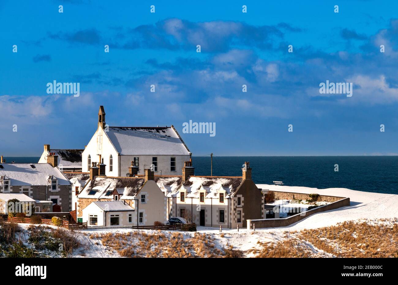 FINDOCHTY MORAY FIRTH SCOTLAND BLEU CIEL UNE VUE D'HIVER LA NEIGE COUVRAIT KIRK OU CHURCH ON THE HILL Banque D'Images
