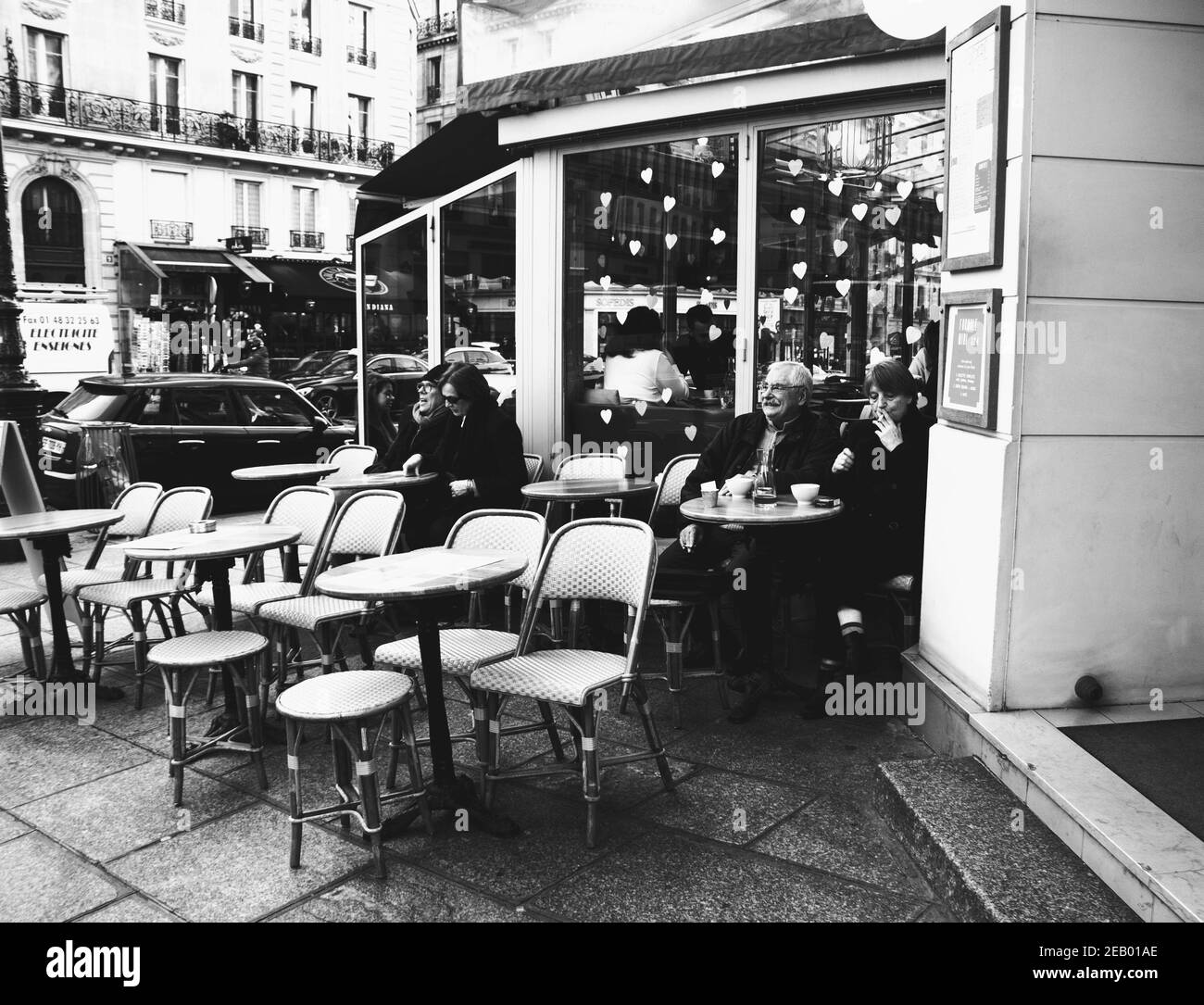 PARIS, FRANCE - 14 FÉVRIER 2019 : les personnes et les ours en peluche sont assis sur la terrasse et à l'intérieur d'un café dans le quartier latin, décoré pour la Saint-Valentin.Noir blanc Banque D'Images