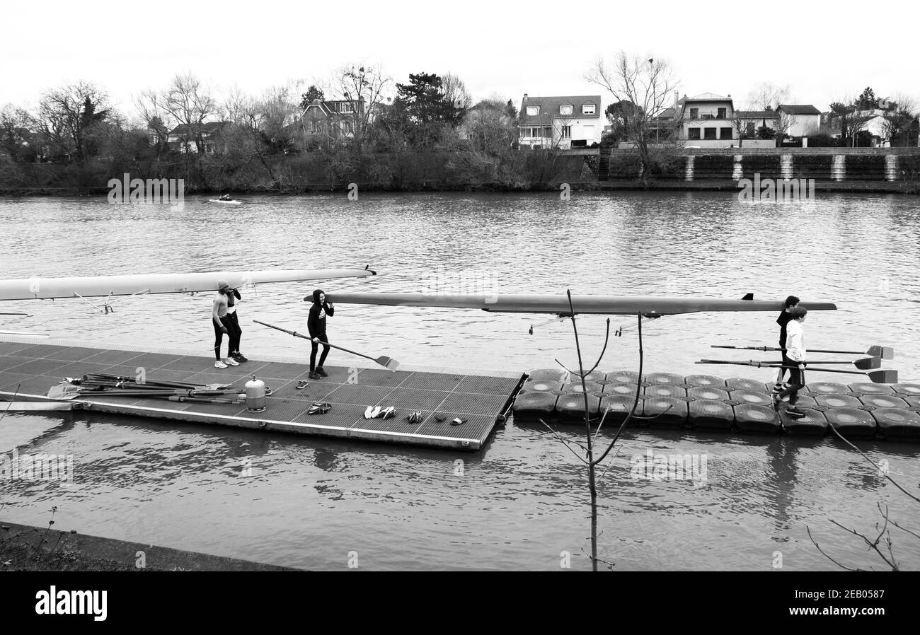 ILE-DE-FRANCE, FRANCE - 26 JANVIER 2019 : formation des jeunes rameurs à la Marne. Les garçons transportant et faisant entrer le bateau dans l'eau. Photo noir et blanc. Banque D'Images