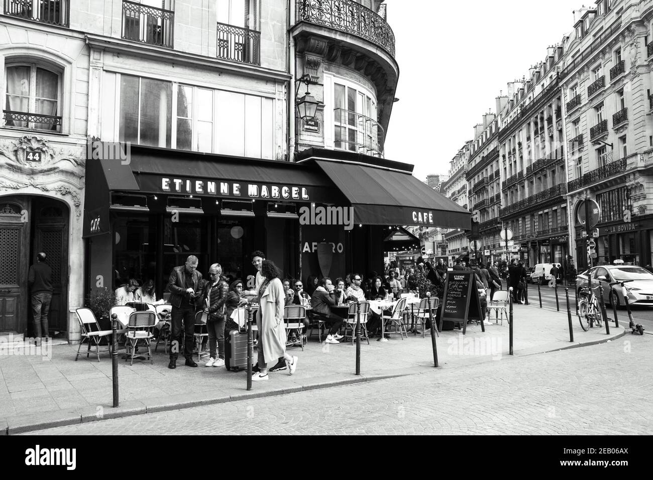 PARIS, FRANCE - 6 AVRIL 2019 : les Parisiens et les touristes s'assoient sur la terrasse du café Etienne Marcel de la rue Montmartre. Photo historique noir blanc Banque D'Images