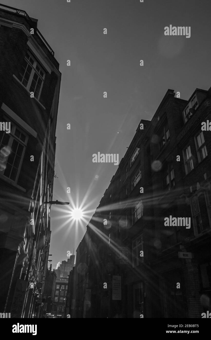 La forte lumière du soleil d'hiver crée une lumière vive et des ombres profondes dans une rue de l'arrière-rue de la ville, Charlotte Road, Londres Banque D'Images