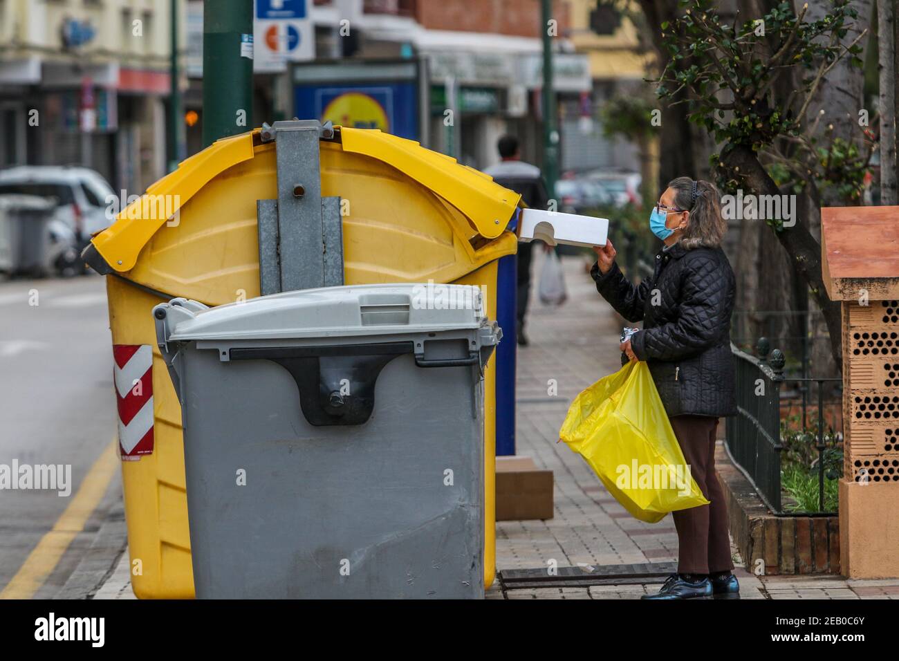 11 février 2021: 11 février 2021 (Malaga) UNE femme recycle une bouteille en verre et carton crédit: Lorenzo Carnero/ZUMA Wire/Alay Live News Banque D'Images