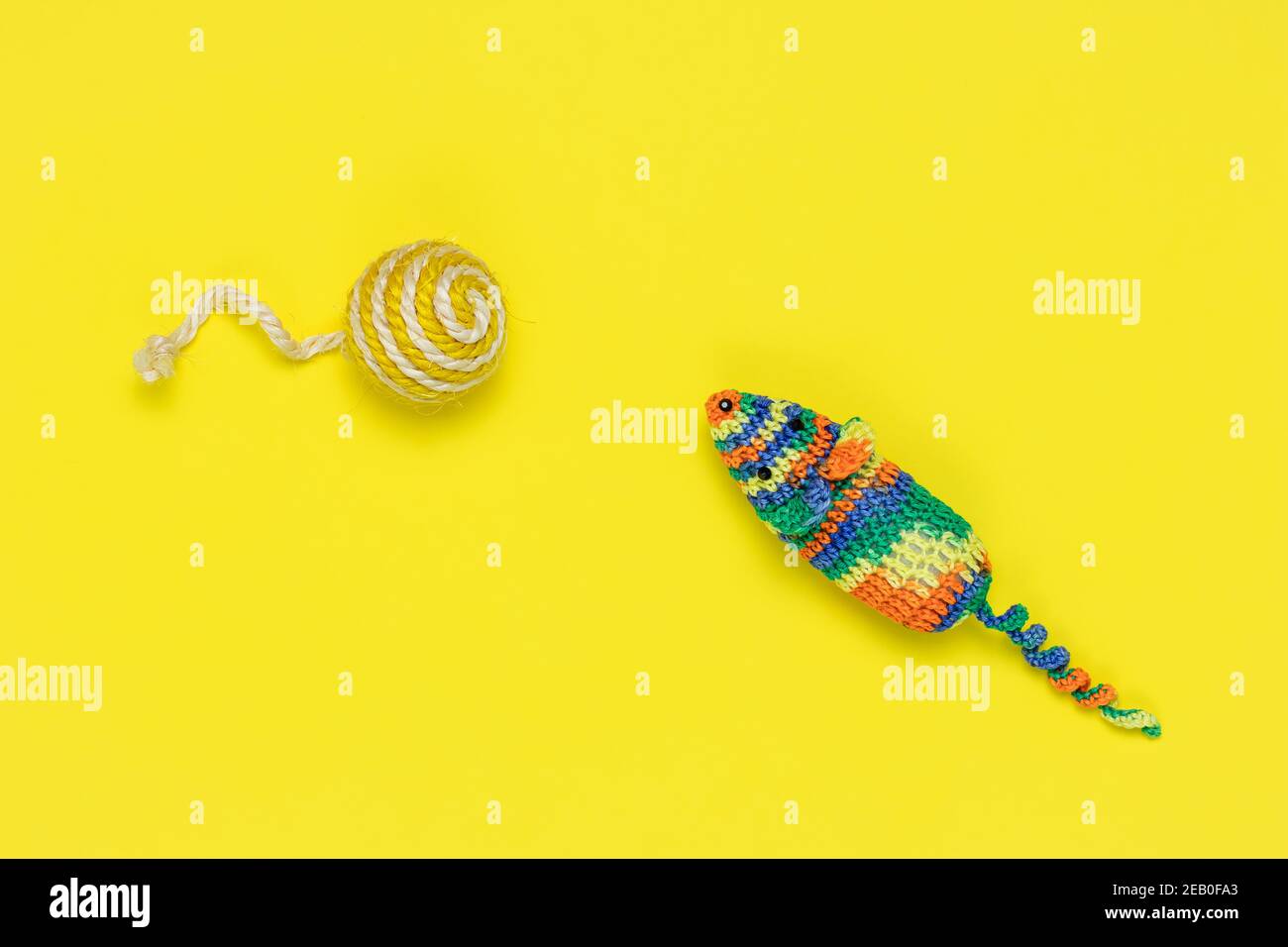 Souris et ballon artificiels pour jouer des chats sur fond jaune vif. Vue de dessus. Jouets tricotés colorés pour animaux de compagnie Banque D'Images