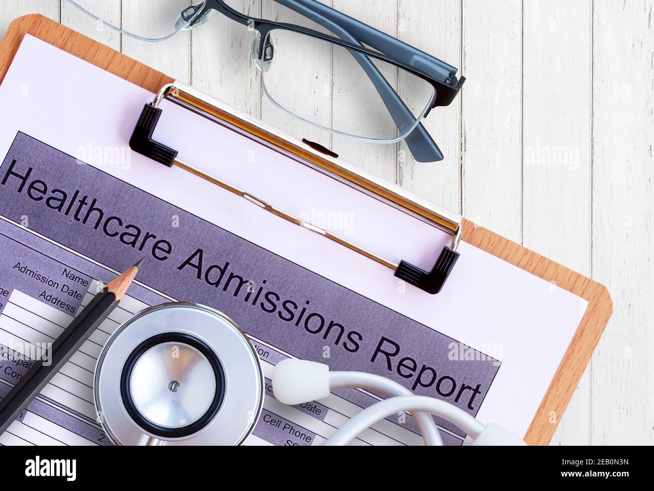 Lieu de travail d'un médecin. Stéthoscope, formulaire de rapport d'admission aux soins de santé, lunettes, crayon sur fond de bureau en bois. Vue de dessus avec espace de copie. Concept de santé Banque D'Images