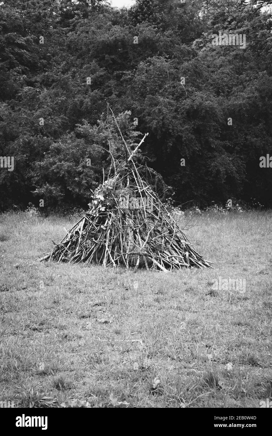 Cabane de branches en bois. Aire de jeux dans la nature, mode de vie naturel de l'enfance, joie simple, concepts de survie. Arrière-plan rétro de nostalgie. Noir W Banque D'Images