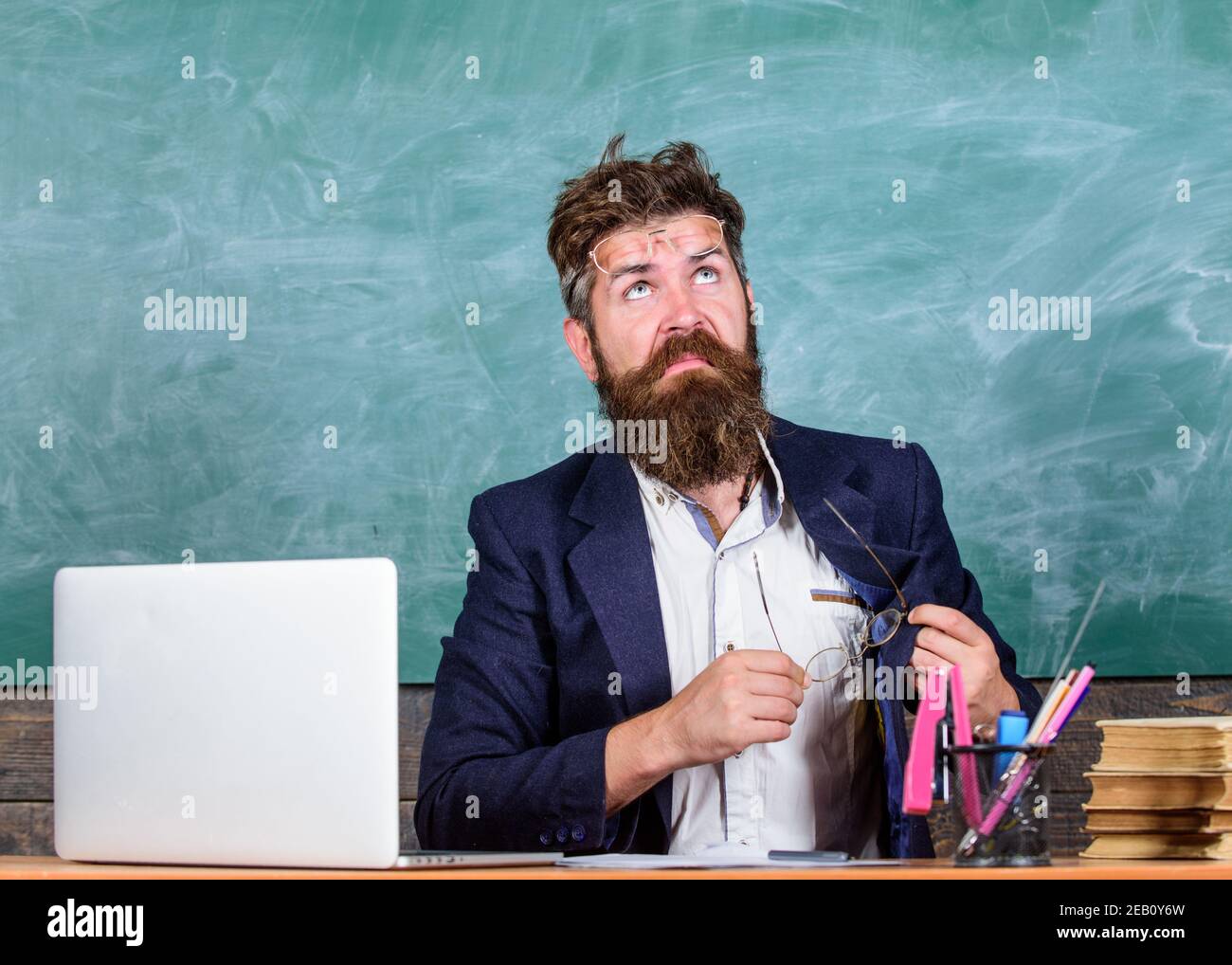 Soins des yeux et santé. Travailler avec un ordinateur portable et des livres cause des problèmes avec les yeux et la vision. Professeur barbu avec des lunettes de soin de la santé des yeux. Vous devez choisir des lunettes appropriées pour garder une bonne vision. Banque D'Images