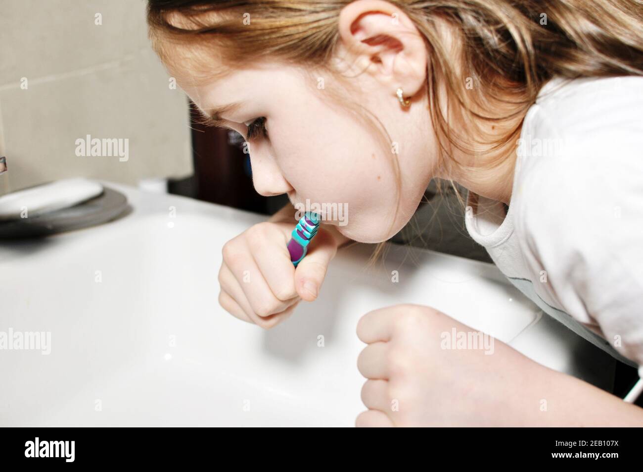 Blanc caucasien enfant (enfant), fille, laver ses dents avec une brosse à dents dans la salle de bains. Soins dentaires. Banque D'Images