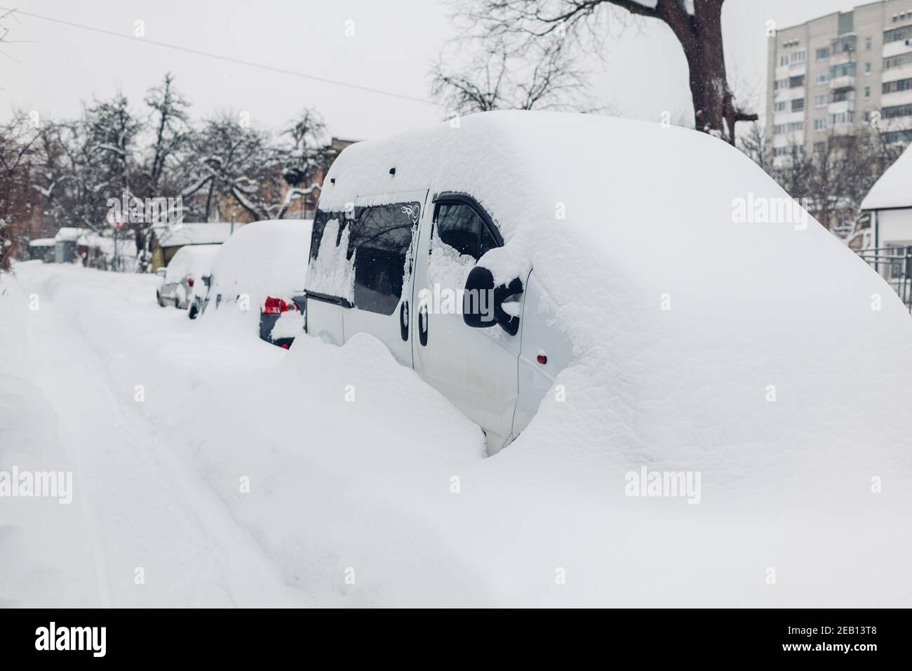 Voitures couvertes de neige pendant la chute de neige en ville. Les automobiles se coincent dans des tas après un blizzard hivernal. 2021 tempête en février en Ukraine Banque D'Images