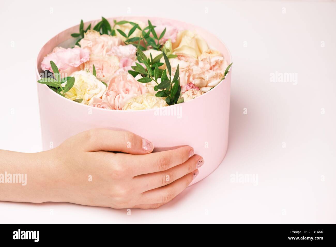 Femme tenant une boîte cadeau avec des fleurs pour le 8 mars, journée internationale des femmes, jour de la Saint Valentin, jour des mères heureux Banque D'Images