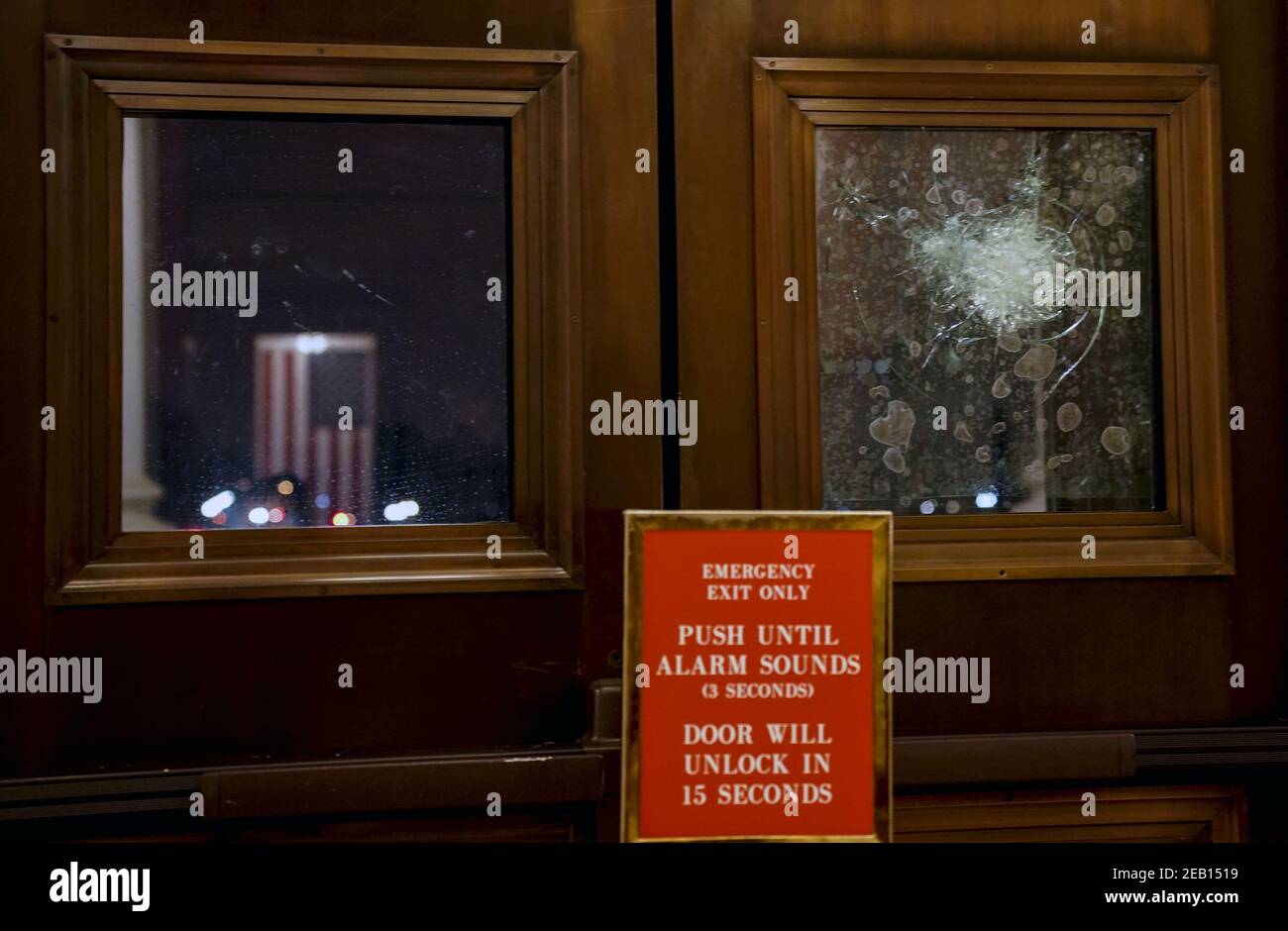 Washington, États-Unis. 11 février 2021. Le drapeau américain se reflète dans une porte lambrissée de verre qui a été brisée par des émeutiers le 6 janvier au Capitole des États-Unis à Washington, DC, le jeudi 11 février 2021. Le matin du 11 février, des travailleurs ont été vus en remplacement du verre brisé. Photo de Leigh Vogel/UPI crédit: UPI/Alay Live News Banque D'Images