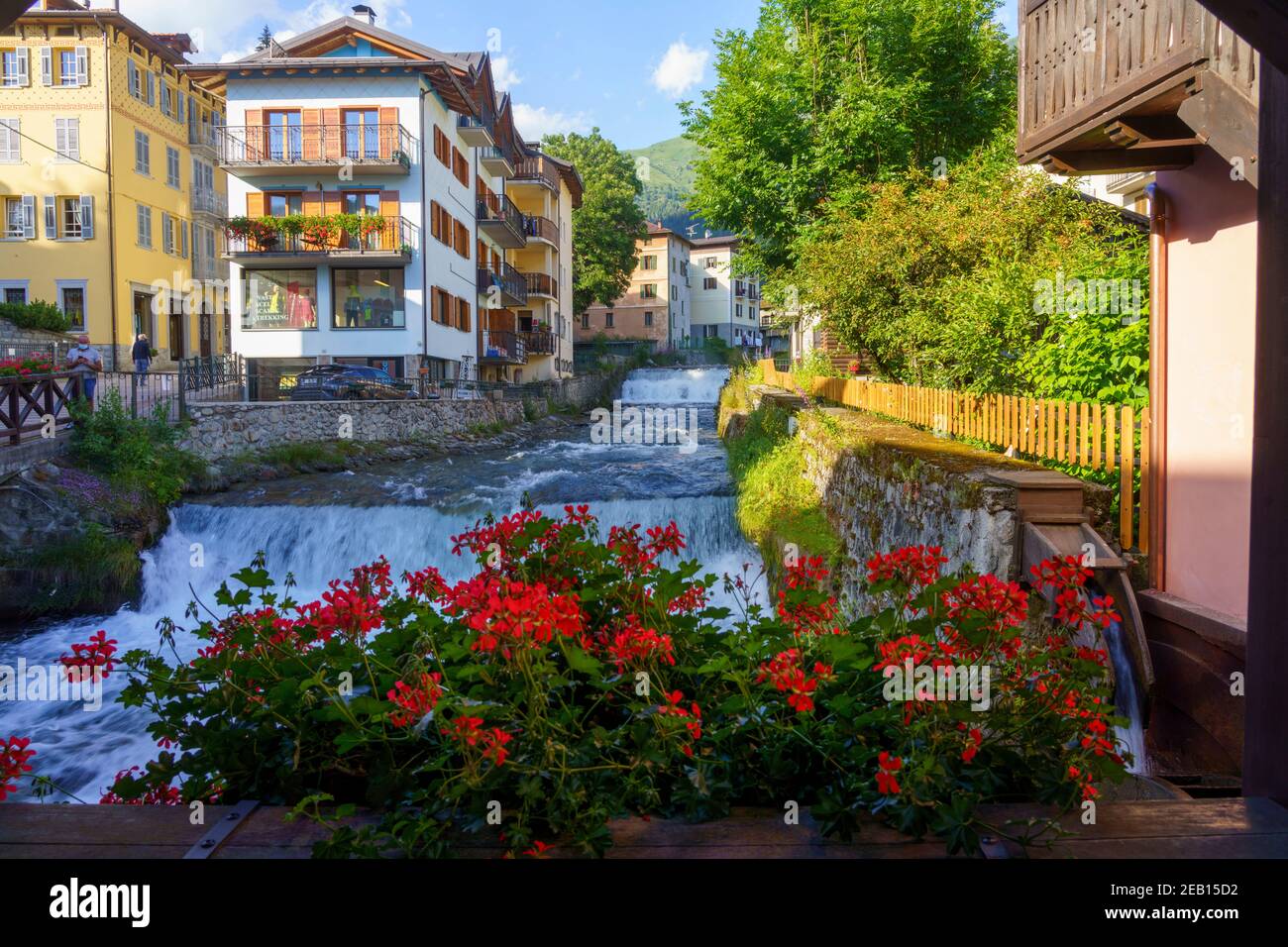Ponte di Legno, province de Brescia, Lombardie, Italie. Vieille ville dans la vallée de la Camonica. Le pont en bois et les fleurs rouges Banque D'Images