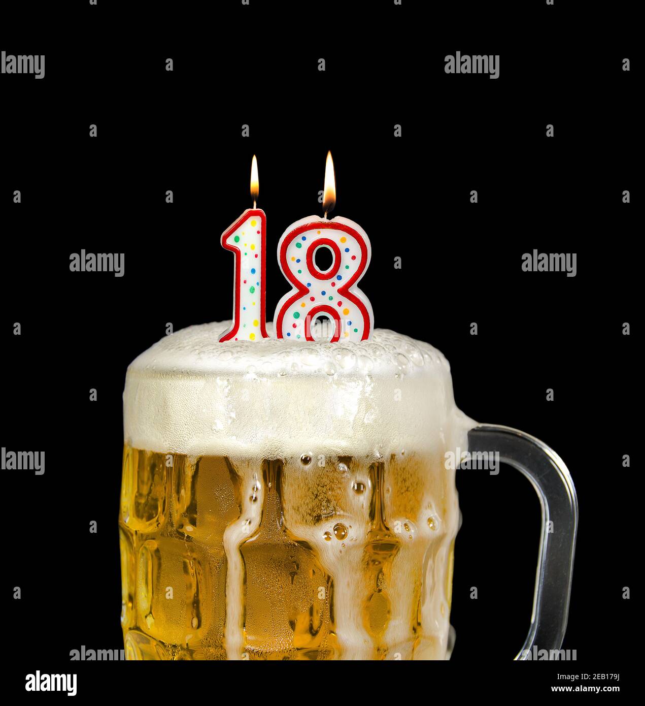 bougie numéro 18 dans une tasse à bière pour la fête d'anniversaire isolée sur le noir Banque D'Images