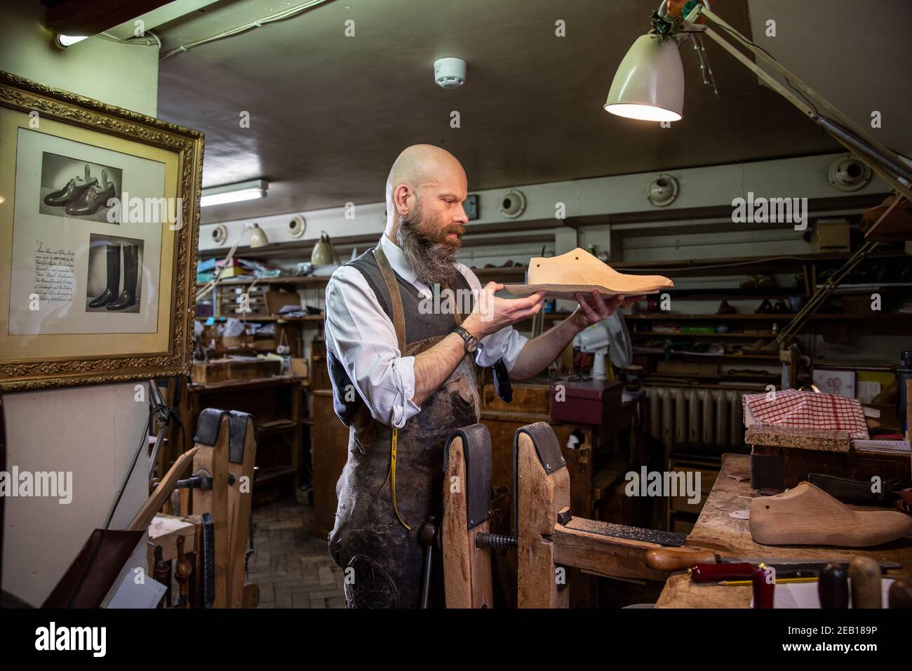 Le monteur et le dernier constructeur travaillent sur son banc à l'intérieur de John Lobb, fabricant des meilleures chaussures et bottes sur mesure faites à la main, Mayfair, Londres, Angleterre, Royaume-Uni Banque D'Images