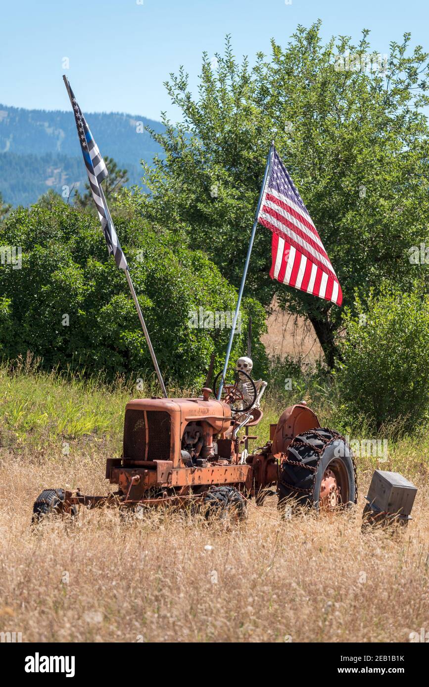 Affichage avec drapeaux et squelette conduisant un tracteur, Adams County, Idaho. Banque D'Images