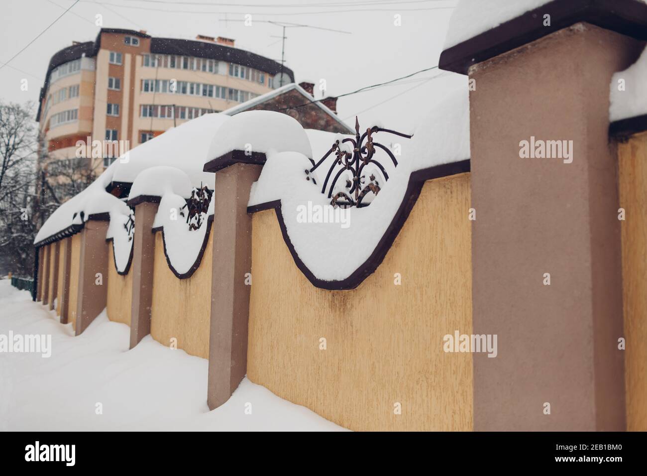 Clôture en pierre avec détails métalliques recouverts d'une épaisse couche de neige après blizzard. Banque D'Images